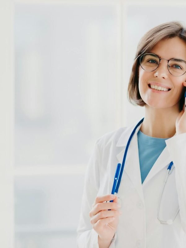 positive-woman-doctor-consults-patient-via-cellphone-looks-gladfully.jpg